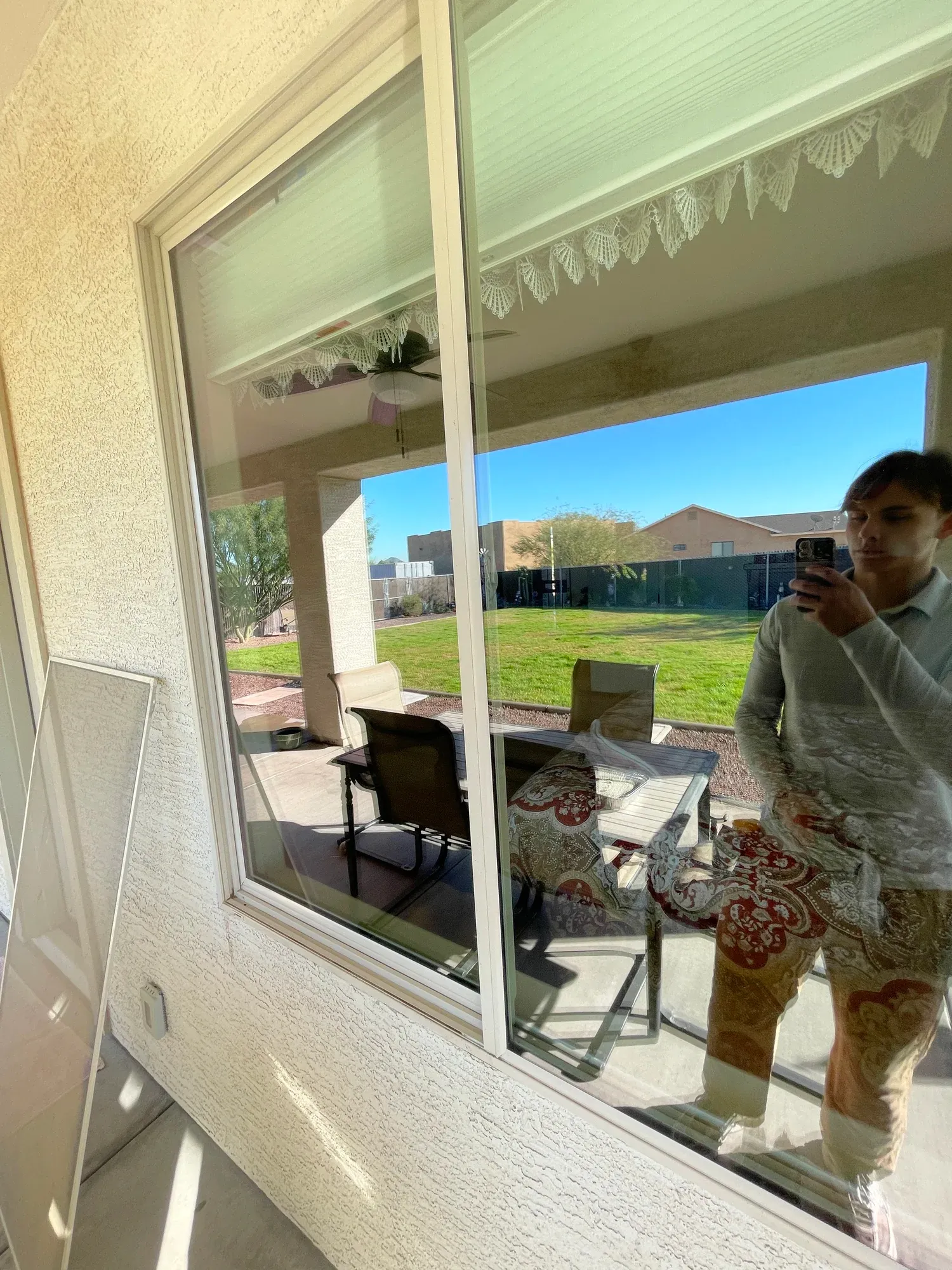 Clean patio glass reflecting a sunny backyard